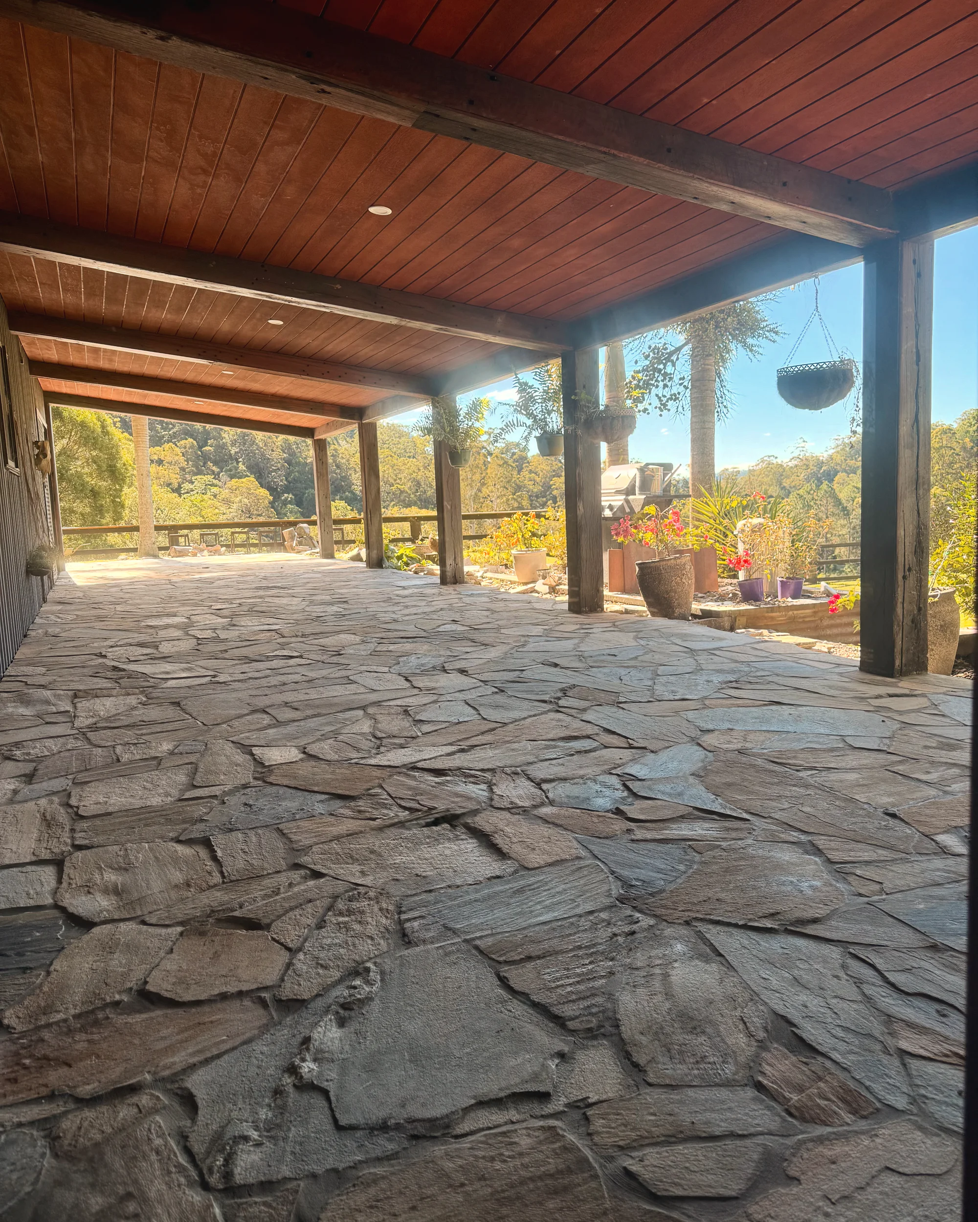 Crazy paving under a timber verandah looking out over the hinterland